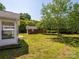 Spacious backyard featuring a small brick building, mature trees and well-maintained grass at 4203 Ethel Sustar Dr, Monroe, NC 28110