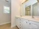 Well-lit bathroom featuring double sinks with white cabinets, tile floor, and a framed mirror at 4203 Ethel Sustar Dr, Monroe, NC 28110