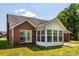 Exterior view of brick house with sunroom addition and a well manicured lawn at 4203 Ethel Sustar Dr, Monroe, NC 28110