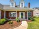 Inviting covered front porch with white pillars and well-kept landscaping, perfect for relaxing at 4203 Ethel Sustar Dr, Monroe, NC 28110
