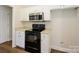 Kitchen area featuring stainless steel microwave, oven and white cabinets at 4203 Ethel Sustar Dr, Monroe, NC 28110