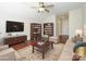 Cozy living room featuring hardwood floors, ample seating, a flat-screen TV, and built-in bookshelves at 4203 Ethel Sustar Dr, Monroe, NC 28110