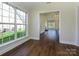 Bright sun room featuring large windows and wood-look flooring, with view of a living room at 4203 Ethel Sustar Dr, Monroe, NC 28110