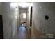 Interior hallway with damaged walls and floors, showcasing the need for renovation at 4814 Chapel Grove Rd, Gastonia, NC 28052