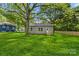 Lovely backyard with lush green grass and plenty of shade from the mature trees overhead at 508 Clegg St, Shelby, NC 28150