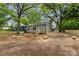 Large backyard with mature trees, newly laid topsoil, and a back entrance with wood stairs at 508 Clegg St, Shelby, NC 28150