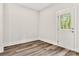 Bright bedroom with wood-style flooring and white door leading outside at 508 Clegg St, Shelby, NC 28150