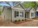 Angle shot of a green house with black shutters and a lush landscaped yard at 508 Clegg St, Shelby, NC 28150