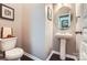 Powder room featuring pedestal sink, wood floors, picture frames and a white toilet at 5150 Mount Clare Ln, Charlotte, NC 28210