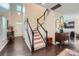 Inviting foyer showcasing hardwood floors, staircase with white railings, and natural light at 5150 Mount Clare Ln, Charlotte, NC 28210