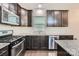 Kitchen featuring dark wood cabinets, granite countertops, stainless steel appliances, and tile backsplash at 5150 Mount Clare Ln, Charlotte, NC 28210