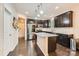 Modern kitchen with dark wood cabinets, granite countertops, stainless steel appliances, and a center island at 5150 Mount Clare Ln, Charlotte, NC 28210