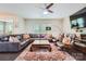 Bright living room features hardwood floors, large leather sectional, stylish furniture, and large windows at 5150 Mount Clare Ln, Charlotte, NC 28210
