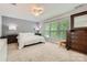 Bright main bedroom with a ceiling fan, three large windows, and a quilted coverlet at 5150 Mount Clare Ln, Charlotte, NC 28210