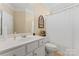 Bright bathroom features a white vanity with gold fixtures, a decorative mirror, and shower with curtain at 536 Wellbourne Nw Ct, Concord, NC 28027