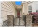 Inviting gated entrance with stone pillars leading to a charming red front door at 536 Wellbourne Nw Ct, Concord, NC 28027