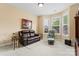 Bright and cozy sitting room with windows, a leather couch, and an ottoman at 536 Wellbourne Nw Ct, Concord, NC 28027