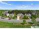 Neighborhood aerial view of a community with well-maintained lawns and tree-lined streets under a bright blue sky at 541 Nw Sutro Forest Dr, Concord, NC 28027