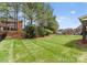Lush, well-manicured backyard with mature trees and a secure black metal fence ensuring privacy and security at 541 Nw Sutro Forest Dr, Concord, NC 28027