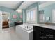 Bright, spa-like bathroom featuring dual vanities, a soaking tub, a separate shower, and natural light at 541 Nw Sutro Forest Dr, Concord, NC 28027