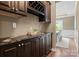 Wet bar and butlers pantry with dark cabinets, granite counter and wine storage at 541 Nw Sutro Forest Dr, Concord, NC 28027