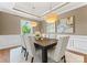 Formal dining room featuring elegant lighting fixtures, wainscoting, and a dark wood table at 541 Nw Sutro Forest Dr, Concord, NC 28027