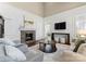 Cozy living room featuring a stone fireplace, large windows, and comfortable seating area at 541 Nw Sutro Forest Dr, Concord, NC 28027