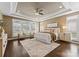 Bright main bedroom with hardwood floors, tray ceiling, ceiling fan, natural light, and decorative rug at 541 Nw Sutro Forest Dr, Concord, NC 28027