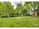 Lush backyard featuring green grass and mature trees, creating a serene outdoor space at 5901 Quail Hollow Rd # G, Charlotte, NC 28210