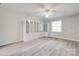 Spacious bedroom with gray wood-look floors, built-in cabinets, and large window at 5901 Quail Hollow Rd # G, Charlotte, NC 28210