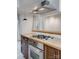 Close up of updated kitchen with wood counters and stainless steel oven and cooktop at 5901 Quail Hollow Rd # G, Charlotte, NC 28210