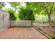 Tiled patio area is surrounded by a white picket fence and lush greenery at 5901 Quail Hollow Rd # G, Charlotte, NC 28210