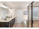 Well-lit bathroom featuring a soaking tub, tiled floors and a large double sink vanity with framed mirrors at 6153 Kilchurn Dr, Fort Mill, SC 29707