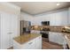 Bright kitchen featuring stainless steel appliances, island, and white cabinets at 6153 Kilchurn Dr, Fort Mill, SC 29707