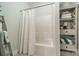 Clean bathroom with a tub/shower combo and shelving unit for organized storage at 637 Williamson Rd # 309, Mooresville, NC 28117