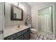 Well-lit bathroom features a blue vanity, framed mirror, and a separate toilet area at 637 Williamson Rd # 309, Mooresville, NC 28117