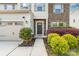 Inviting front entrance with stone detailing, colorful landscaping, and a two-car garage at 6702 Carradale Way, Charlotte, NC 28278
