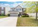 Charming two-story home featuring stone accents, a well-maintained lawn, and a two-car garage at 6702 Carradale Way, Charlotte, NC 28278
