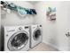 A functional laundry room with modern appliances, storage shelves, and practical tile flooring at 6702 Carradale Way, Charlotte, NC 28278