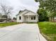 Inviting single-story home features a charming front porch, well-lit by many windows, and a modern driveway at 712 N Washington St, Shelby, NC 28150