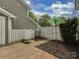 A private backyard with stylish landscaping and white wooden fence at 8251 Tradd Ct, Charlotte, NC 28210