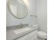 Stylish half bathroom with granite countertop, round mirror, and modern fixtures at 8251 Tradd Ct, Charlotte, NC 28210