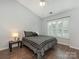 Relaxing bedroom with hardwood floors, a window with shutters, and a ceiling fan at 8251 Tradd Ct, Charlotte, NC 28210