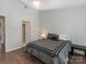 Comfortable bedroom with a soft grey duvet, hardwood floors, and lots of natural light at 8251 Tradd Ct, Charlotte, NC 28210