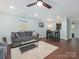 Inviting living room with dark wood floors, modern furniture, and a light blue accent wall at 8251 Tradd Ct, Charlotte, NC 28210