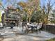An outdoor patio with stone fireplace, an outdoor dining table, and seating for outdoor living at 8251 Tradd Ct, Charlotte, NC 28210