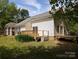View of home's backyard with wooden deck and patio area surrounded by lush greenery at 8332 Highlander Ct, Charlotte, NC 28269