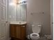 Standard bathroom featuring a single sink vanity, toilet, and neutral wall color at 8332 Highlander Ct, Charlotte, NC 28269