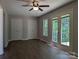 Cozy main bedroom with double doors leading to the back deck features a ceiling fan at 8332 Highlander Ct, Charlotte, NC 28269