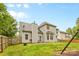 View of the backyard with grass, a swing set, patio area with an umbrella and a black grill at 9010 Davis Crossing Ct, Charlotte, NC 28269